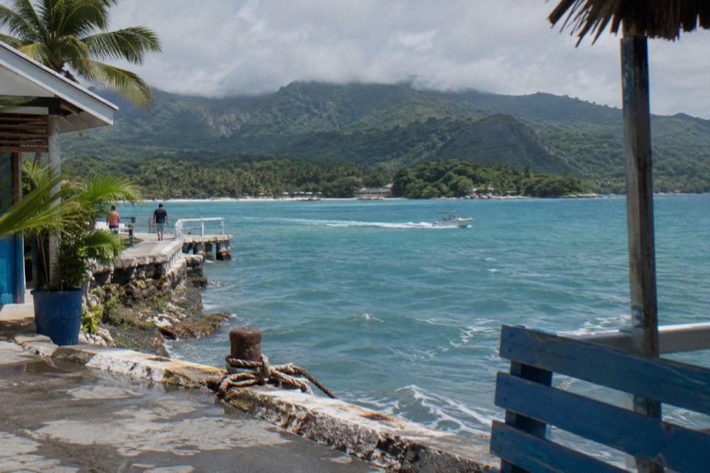 Turquoise bay water framed by dense green hills along the Samana peninsula coastline