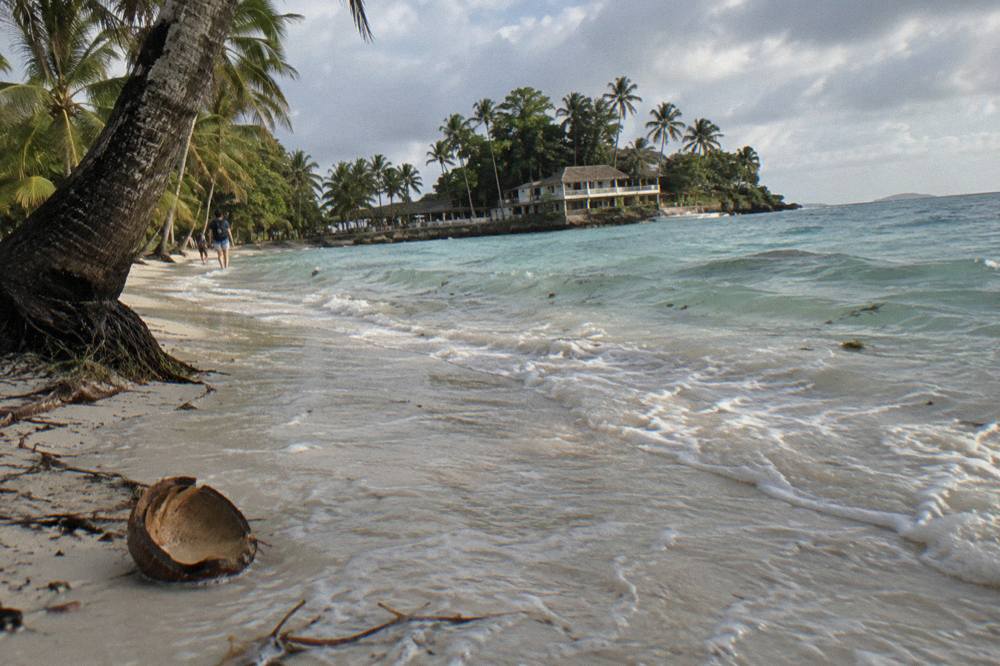 White sand beach with palm trees and calm shallow turquoise water
