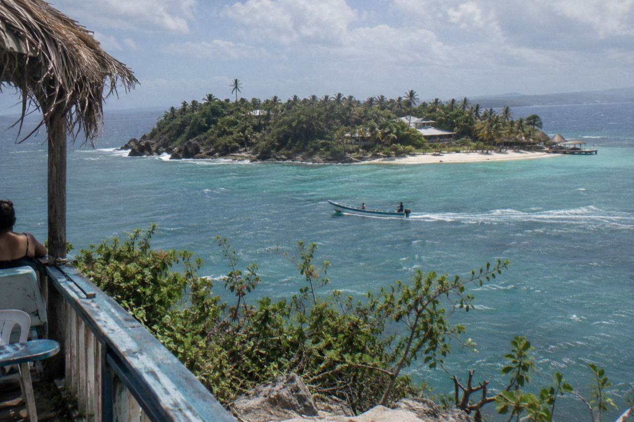 A small palm covered island with white sand and turquoise water in Samana Bay