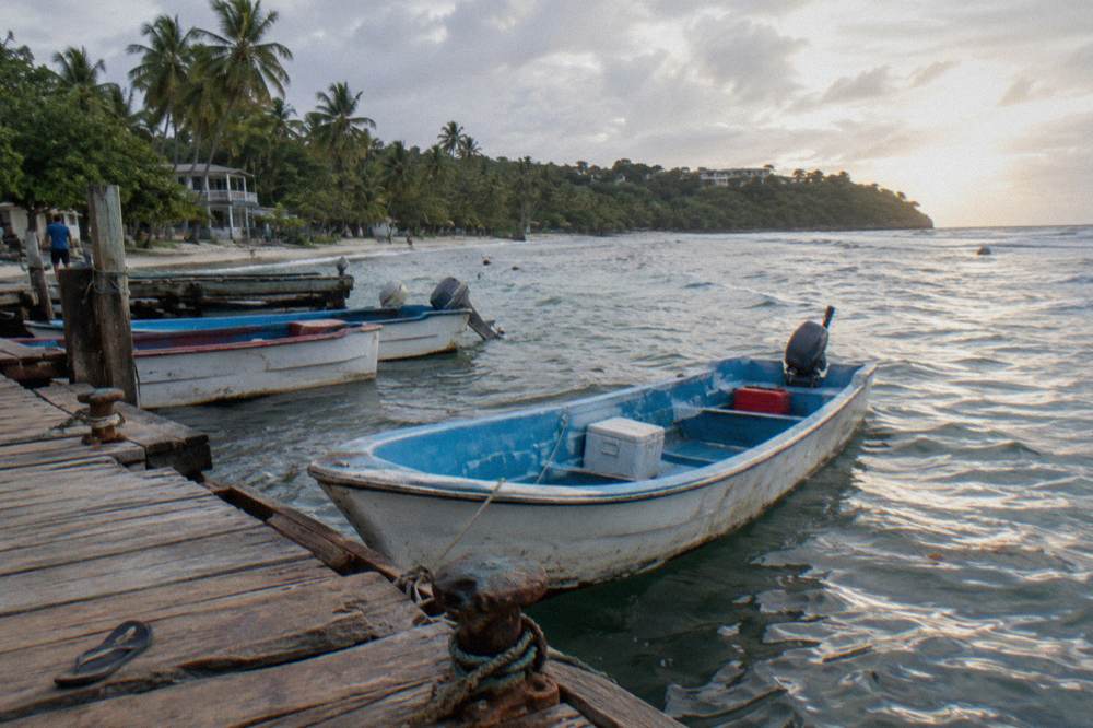 Small wooden boats moored at a waterfront dock in morning light