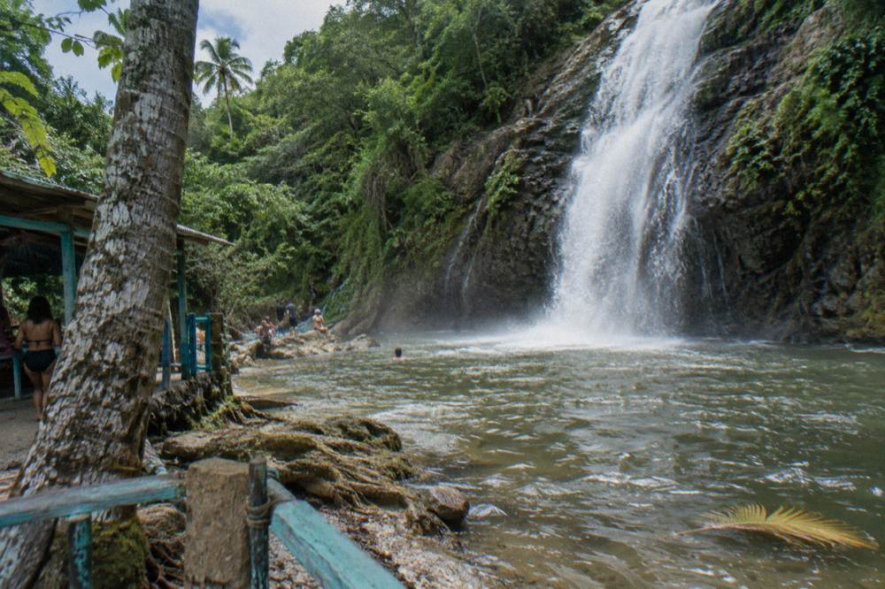 Waterfall dropping into a natural pool surrounded by tropical forest