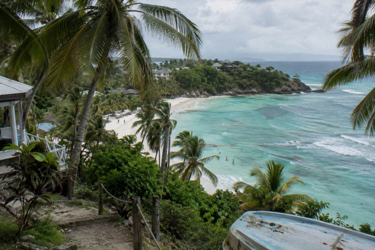 White sand beach with palm trees and turquoise water on an island in Samana Bay