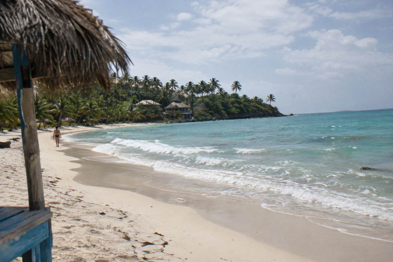 Turquoise water and palm trees on a small island beach in Samana Bay
