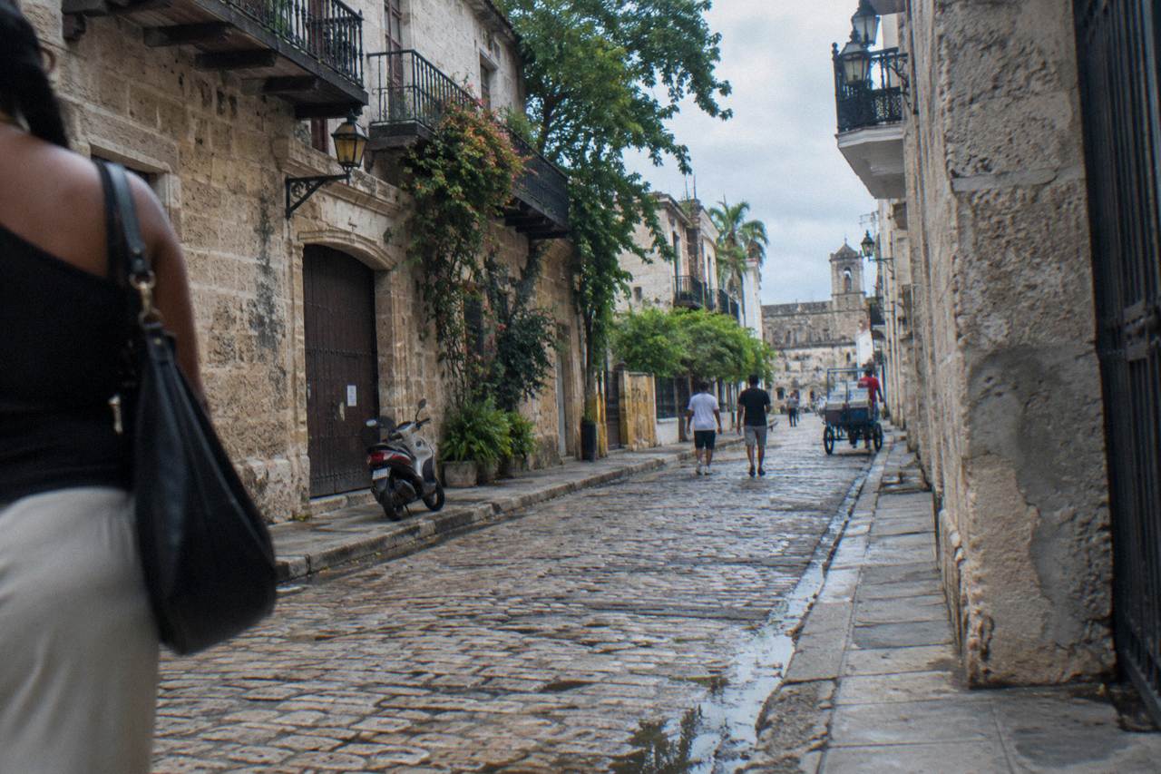 Cobblestone street in Santo Domingo's Colonial Zone lined with old stone buildings in warm afternoon light