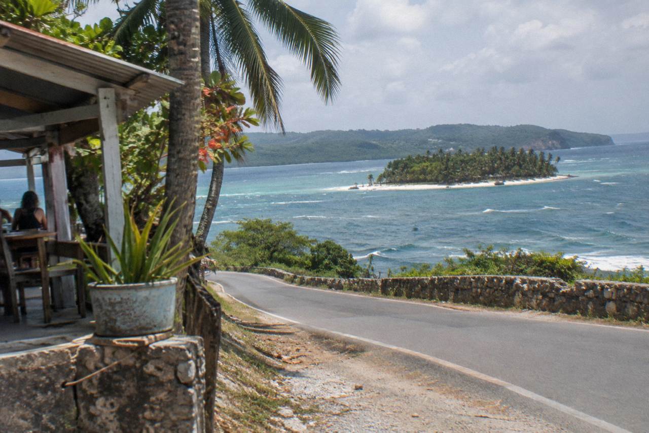 Coastal highway winding along the Samana peninsula toward green hills and the bay