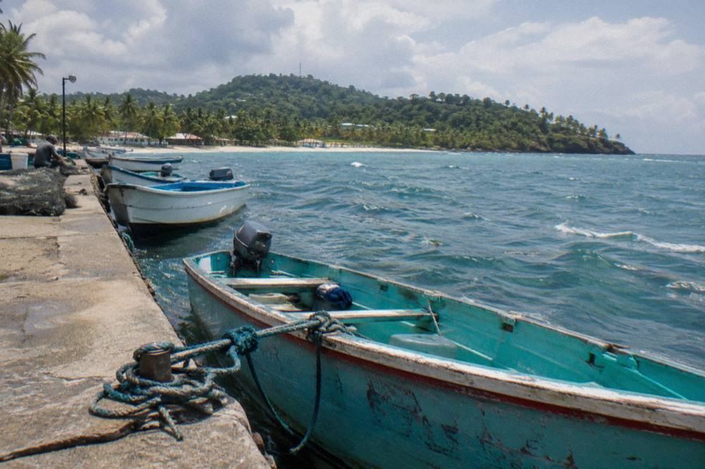 Colorful wooden boats moored along the Samana malecon waterfront at midday